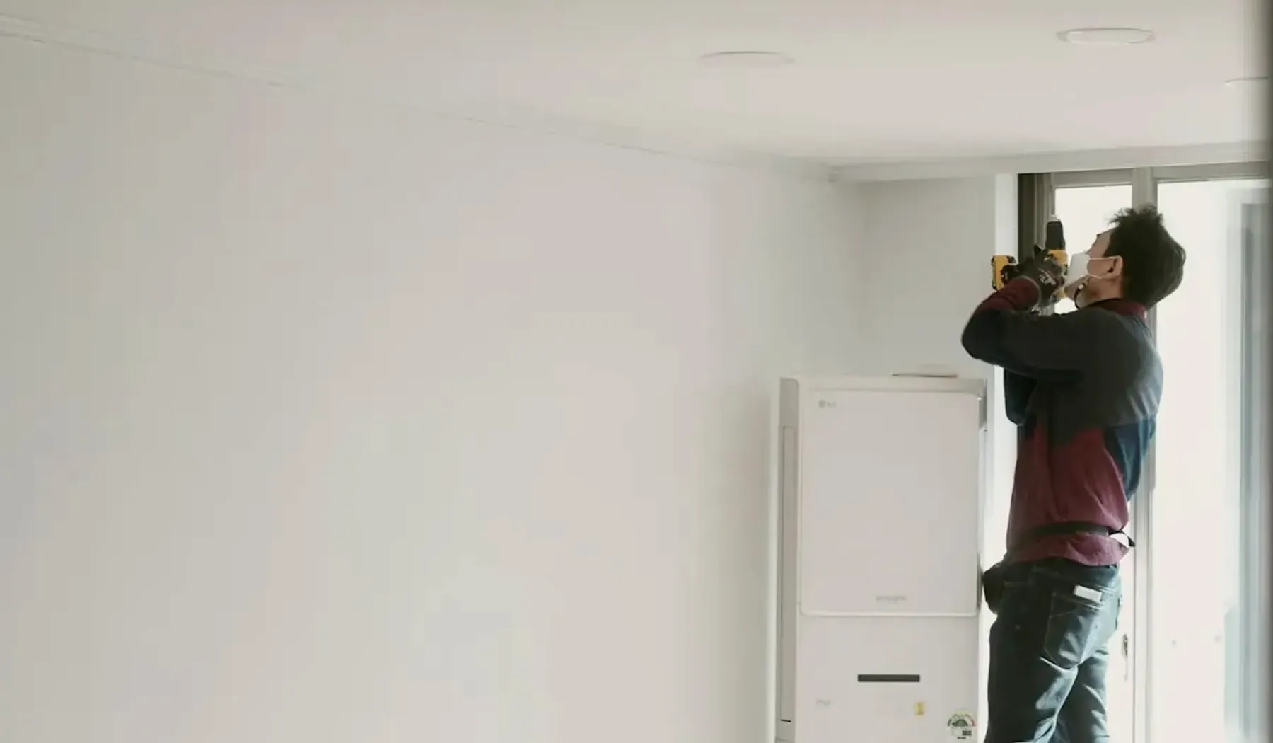 Handwerker auf der Leiter in einem hellen, weißen Raum (Beispielbild)